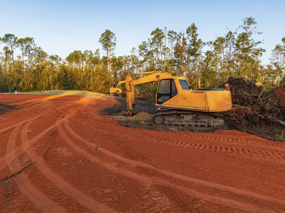 Land clearing with an excavator on a freshly cleared lot